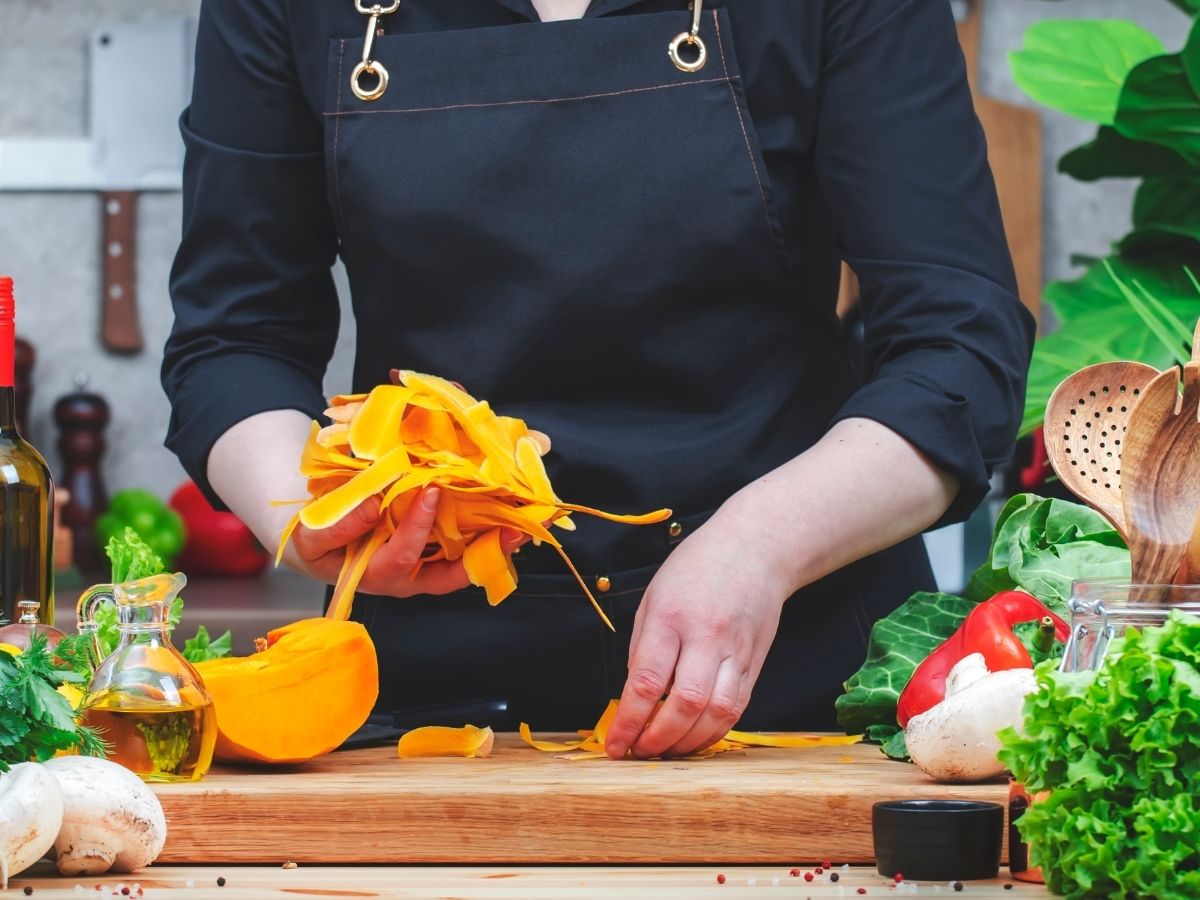 cook collects pumpkin peels for composting