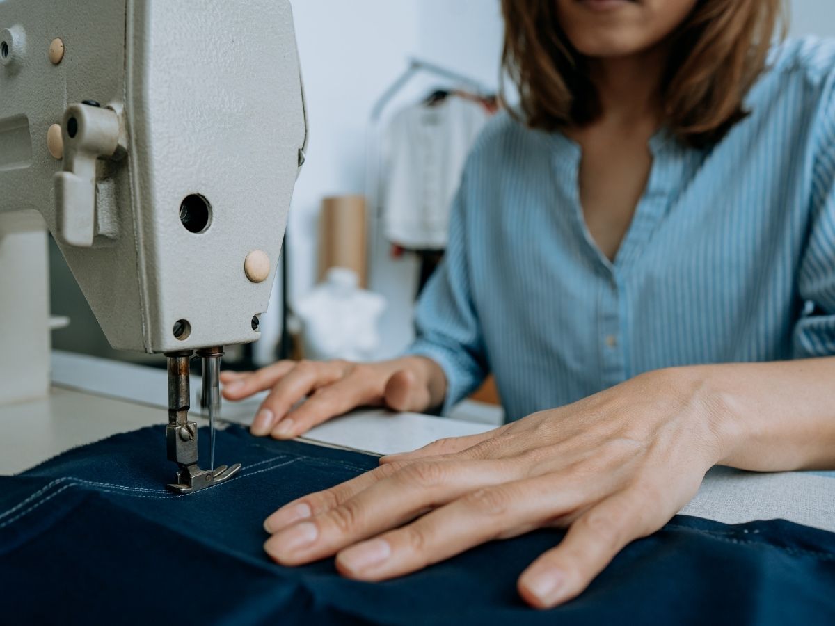 women's hands using sewing machine to sew
